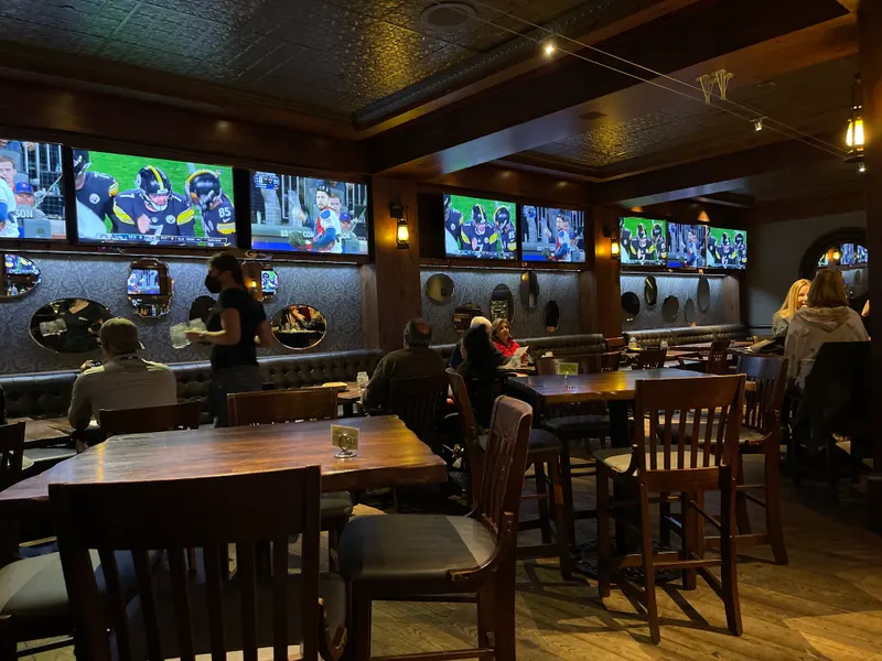 Wood tables and chairs in front of the bar at Cutthroat's Saloon in the Hyatt Regency Lake Tahoe.
