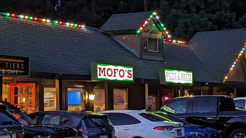The Mofo's Pizza and Pasta storefront with holiday lights along the roof.