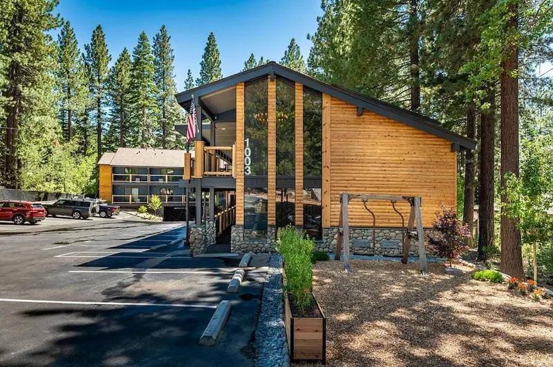 The wood and glass front of the Parkside Inn among pine trees.