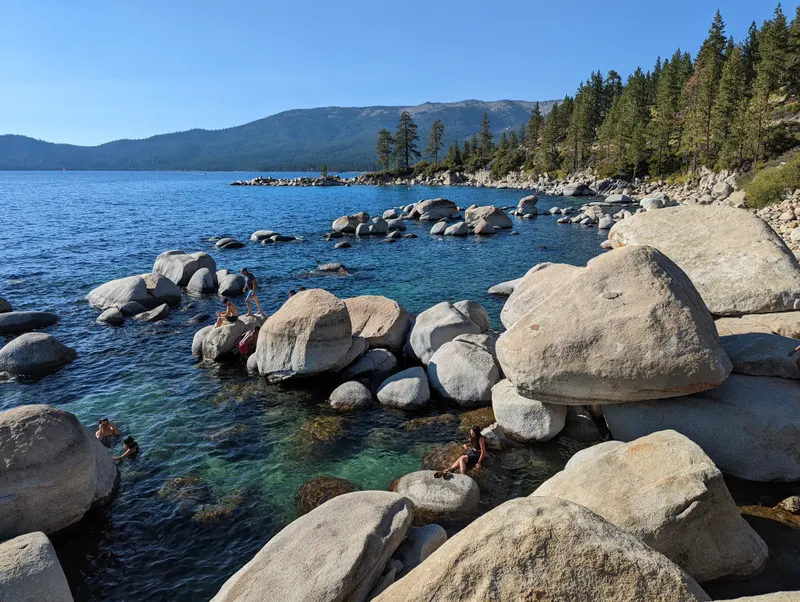 Large smooth boulders sitting in clear blue water at Hidden Beach.