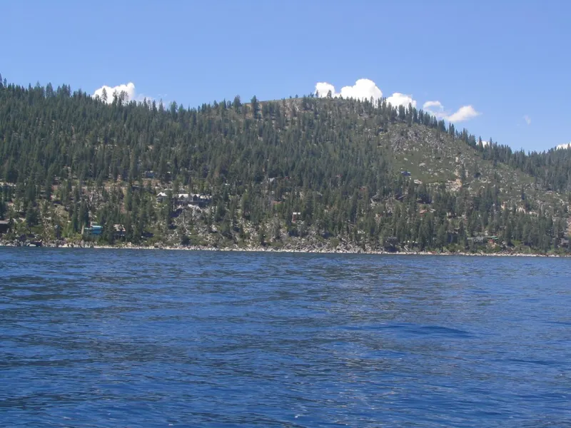 Blue water of Lake Tahoe with the forested shoreline near Incline Village behind.