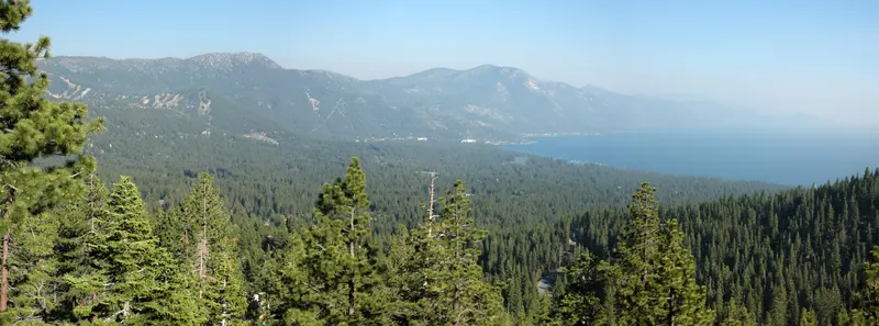 A wide, hazy view over Incline Village and Lake Tahoe from the hills above. Wildfire smoke from California (2008) hides much of the southern view.