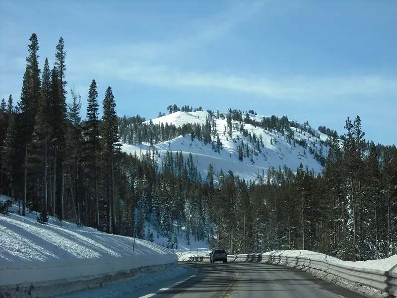 A snow-covered hillside near the Mt. Rose summit, seen from the highway with snow banks along the road.