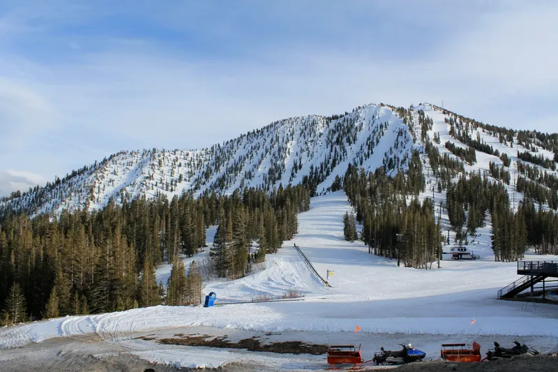 Snow-covered Mt. Rose ski slopes and a lift line under a pale winter sky, with forested ridges beyond.
