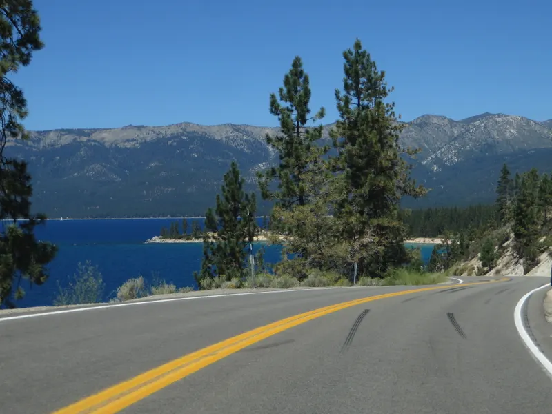 SR 28 curves along the East Shore above deep blue Lake Tahoe, with the mountains of the west shore behind.