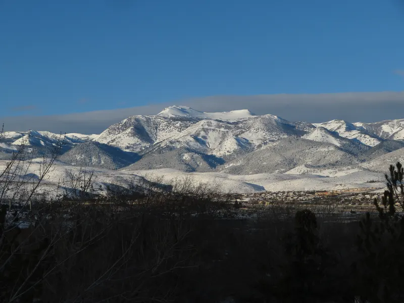 Snow-covered Mt Rose and its neighboring peaks under a clear blue sky at sunrise.