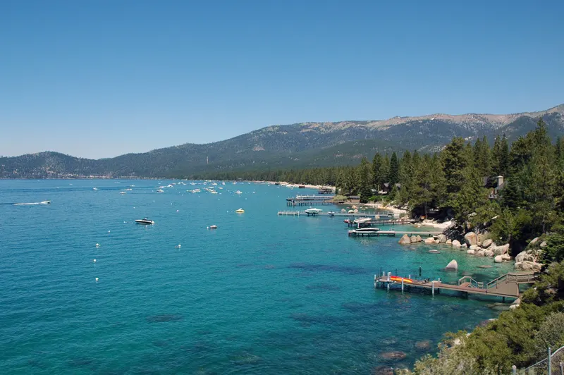 Lake Tahoe north shore near Incline Village with clear turquoise water, private docks and mountains behind.