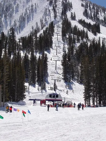 Skiers at the base of the Zephyr East Bowl Express chairlift at Mt. Rose, with snowy slopes above.